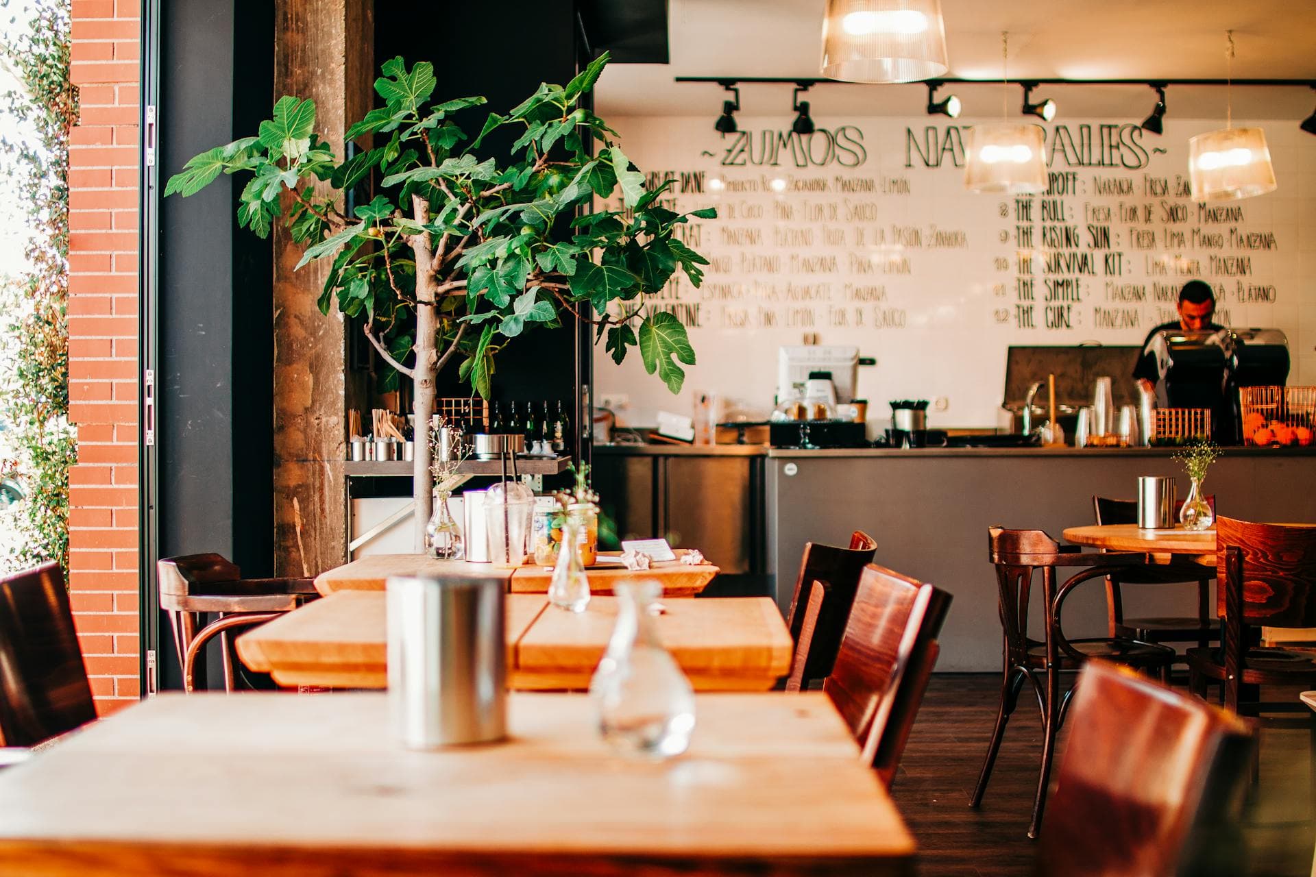 Interior de cafetería con mesas de madera y ambiente acogedor
